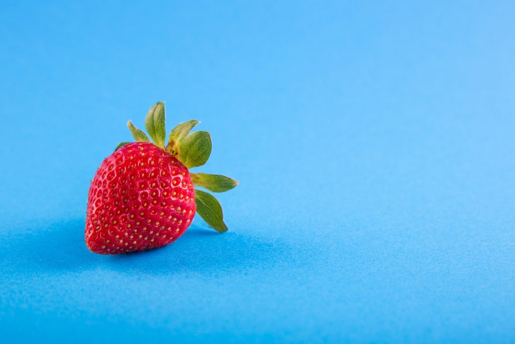 photographie produit fraise rouge sur fond bleu pour exemple de packshot social media food