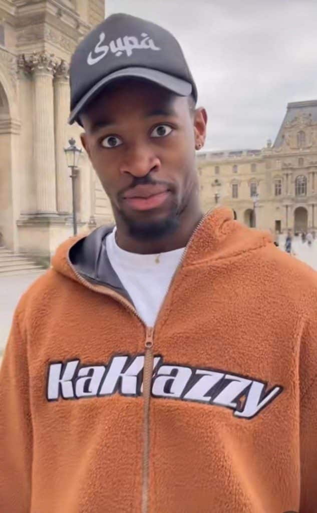 jeune homme en pull lacoste pose pour un visuel campagne devant decor exterieur